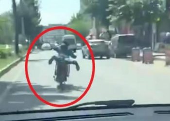Motosikleti akan trafikte, üzerine yüzüstü yatarak kullandı